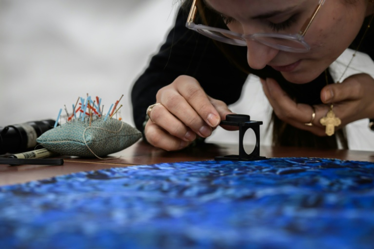 Restauration d'une pièce antique, au Musée des Tissus de Lyon, le 22 novembre 2024 ( AFP / JEAN-PHILIPPE KSIAZEK )