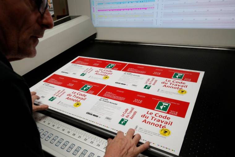 Un employé vérifie les copies du Code du travail français annoté 2018 qui sont mises à jour via une application à l'imprimerie de Choisy-le-Roi