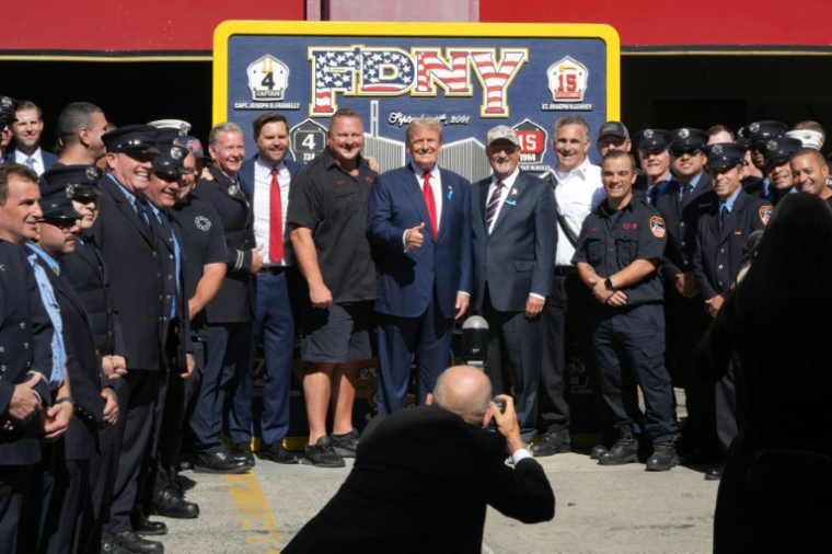 L'ancien président et candidat républicain Donald Trump pose avec des pompiers à New York, le 11 septembre 2024 ( AFP / Bryan R. SMITH )