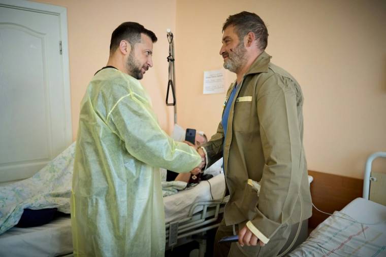 Le président ukrainien Volodymyr Zelensky (g) salue un soldat blessé dans un hôpital de Kharkiv, le 16 mai 2024 ( Service de presse de la présidence ukrainienne / Handout )