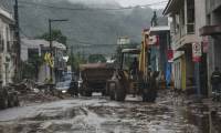 Un ouvrier nettoie une rue avec un engin de travaux après les inondations causées par de fortes pluies à Mucum, dans l'État du Rio Grande do Sul, au Brésil, le 10 mai 2024 ( AFP / Gustavo Ghisleni )