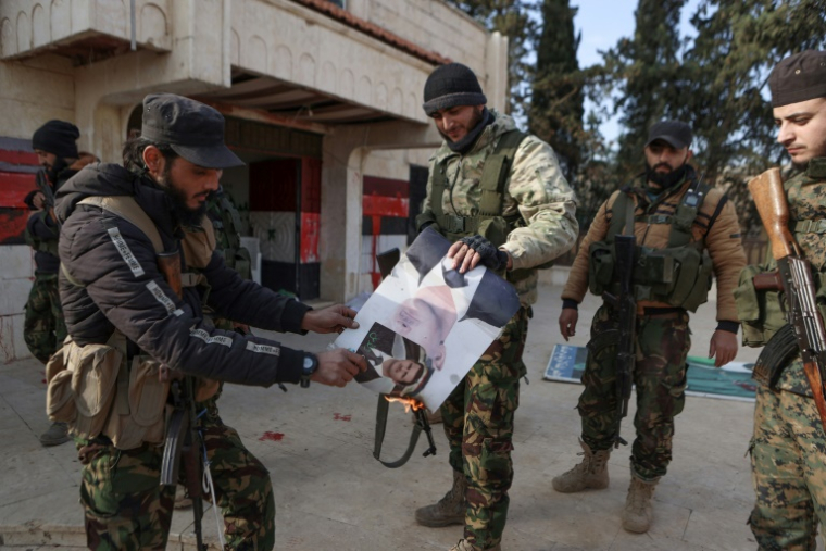 Des combattants brûlent un portrait du président syrien Bachar al-Assad dans la localité de Zarbah, dans le nord-ouest de la Syrie, prise par les jihadistes et leurs alliés, le 29 novembre 2024 ( AFP / AAREF WATAD )