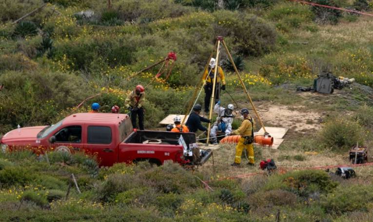 Un secouriste descend dans un puits où des cadavres ont été découverts, le 3 mai 2024 à Ensenada, dans le nord-ouest du Mexique ( AFP / Guillermo Arias )