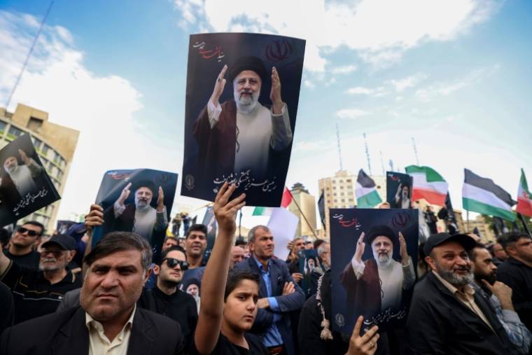 Des Iraniens rassemblés à Téhéran, pour pleurer la mort du président Ebrahim Raissi, du ministre des Affaires étrangères Hossein Amir-Abdollahian et de sept autres personnes dans un accident d'hélicoptère survenu la veille, le 20 mai 2024 ( AFP / ATTA KENARE )