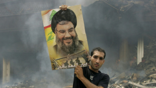 Un Libanais brandit une photo de Hassan Nasrallah après des frappes aériennes israéliennes sur un bastion du Hezbollah à  Beyrouth, le 23 juillet 2006 ( AFP / RAMZI HAIDAR )