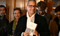 L'écrivain franco-algérien Kamel Daoud (c), lauréat du prix Goncourt pour son roman "Houris", au restaurant Drouant à Paris, le 4 novembre 2024 ( AFP / JULIEN DE ROSA )