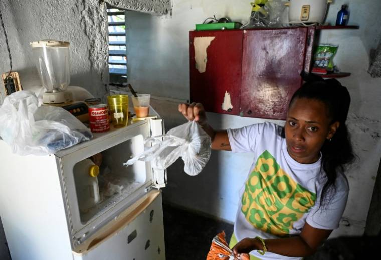 Diana Ruiz montre la nourriture qu'elle a dans son réfrigérateur, chez elle à La Havane, le 27 mars 2024 à Cuba ( AFP / YAMIL LAGE )