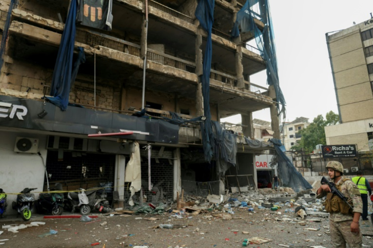 Un soldat de l'armée libanaise monte la garde devant un bâtiment visé par une frappe aérienne dans la banlieue sud de Beyrouth, le 2 novembre 2024 (AFP / IBRAHIM AMRO)