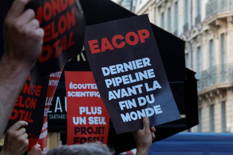 Des manifestants pour le climat aux abords de la salle où doit se dérouler l'assemblée générale annuelle de TotalEnergies, le 26 mai 2023 à Paris ( AFP / Geoffroy VAN DER HASSELT )
