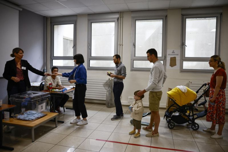 Les Parisiens font la queue pour voter au deuxième tour des élections législatives françaises