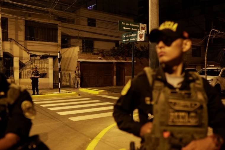 Des policiers montent la garde devant la maison de la présidente Dina Boluarte lors d'une perquisition ordonnée par le bureau du procureur général dans le cadre d'une enquête pour "enrichissement illicite", à Lima, le 30 mars 2024 ( AFP / Juan Carlos CISNEROS )