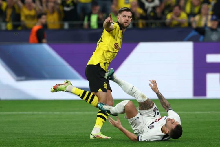 L'attaquant du Borussia Dortmund Niclas Füllkrug (g) marque malgré le retour du Parisien Lucas Hernandez (d) qui s'est blessé sur l'action, le 1er mai 2024 à Dortmund ( AFP / FRANCK FIFE )