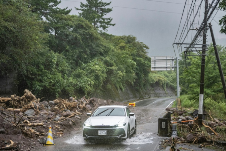 Un automobilista su una strada allagata a Yufu, nella prefettura di Oita, durante il tifone Shanshan il 29 agosto 2024 in Giappone (AFP/Yuichi YAMAZAKI)