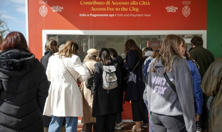 Des touristes font la queue devant la gare Santa Lucia pour acheter des billets d'entrée pour la journée, le 25 avril 2024 à Venise ( AFP / MARCO BERTORELLO )