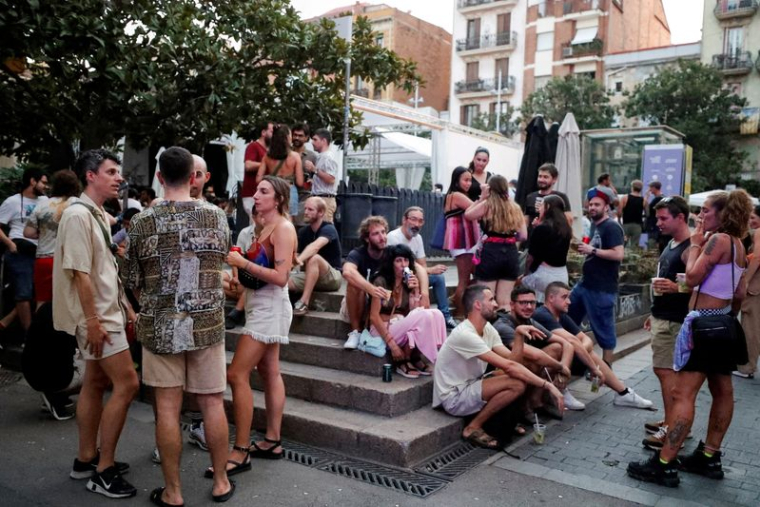 PHOTO DE FICHIER : Des touristes et des résidents boivent dans une rue du quartier de Gracia pendant la canicule de l'été, à Barcelone