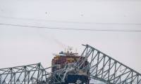 Le pont Francis Scott Key effondré et le porte-conteneurs Dali qui l'a percuté, à Baltimore, aux Etats-Unis, le 27 mars 2024 ( AFP / Jim WATSON )