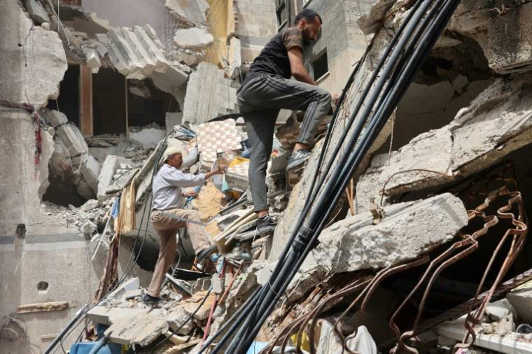 Des Palestiniens fouillent les décombres d'un bâtiment touché par des frappes israéliennes dans le quartier d'Al-Daraj, à Gaza, le 23 mai 2024 ( AFP / Omar AL-QATTAA )