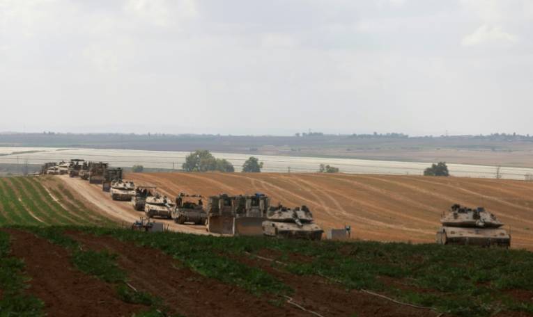Des chars et des véhicules militaires israéliens roulent près de la frontière avec la bande de Gaza, le 12 mai 2024 ( AFP / Menahem KAHANA )