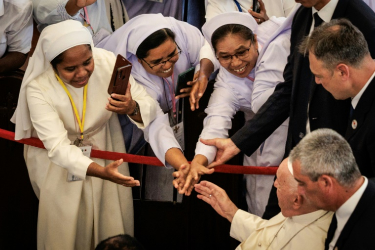 Le pape François (d) est accueilli à son arrivée pour une rencontre avec les évêques, prêtres, diacres, personnes consacrées, séminaristes et catéchistes à la cathédrale de l'Immaculée Conception à Dili, le 10 septembre 2024 ( AFP / Yasuyoshi CHIBA )