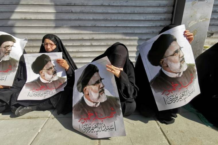 Des pleureuses portent des portraits du président Ebrahim Raïssi, le 22 mai 2024, à Téhéran, en Iran ( AFP / Atta KENARE )