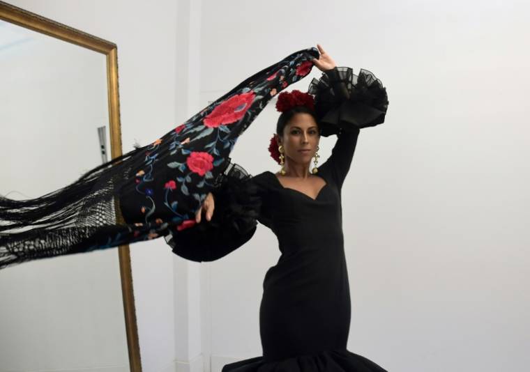 Virginia Cuaresma essaie une robe de flamenco noire dans l'atelier du couturier espagnol Luis Fernandez, le 8 avril 2024 à Séville ( AFP / CRISTINA QUICLER )