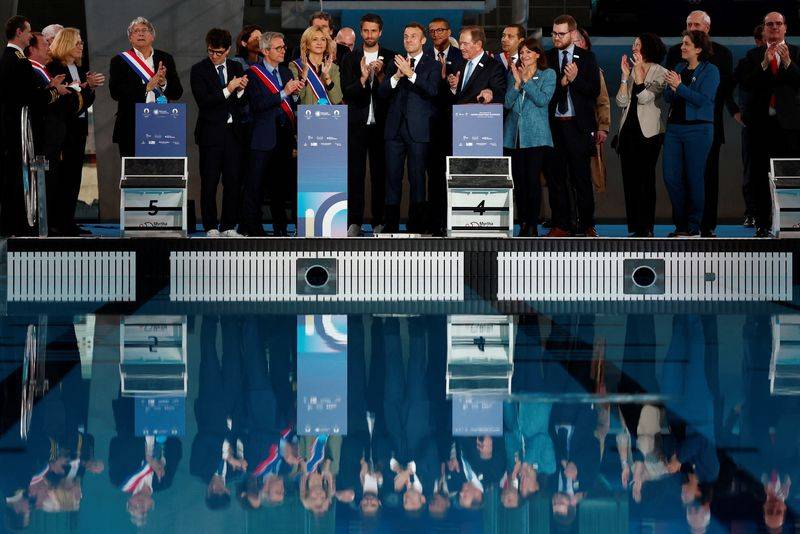Le président français Emmanuel Macron et des responsables lors de l'inauguration du Centre aquatique olympique (CAO), à Saint-Denis