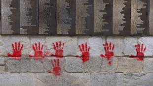Des mains rouges taguées sur le Mur des Justes au Mémorial de la Shoah à Paris, le 14 mai 2024 ( AFP / Antonin UTZ )