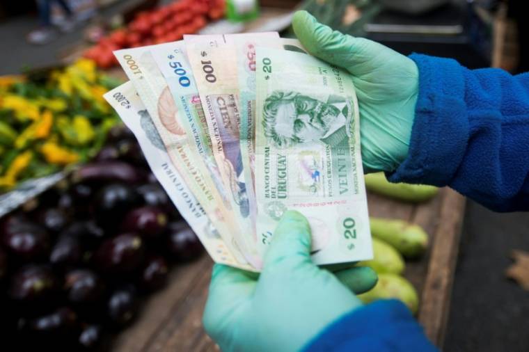 Des billets de banque uruguayens sur un marché à Montevideo, le 23 avril 2024 ( AFP / Pablo VERA )