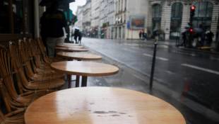 Une terrasse déserte sous la pluie, le 30 mai 2024 à Paris  ( AFP / Sami KARAALI )