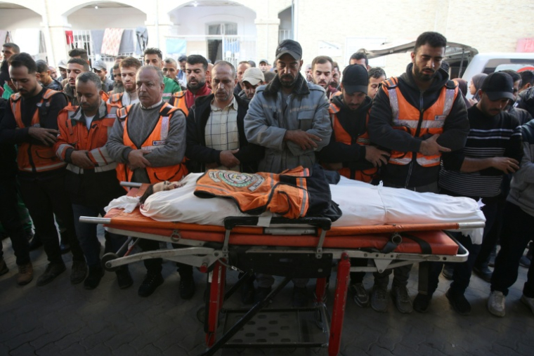 Des Palestiniens se recueillent sur le corps d'un membre de la Défense civile, tué dans une frappe nocturne, à l'hôpital arabe Al-Ahli dans la ville de Gaza, le 20 novembre 2024 ( AFP / Omar AL-QATTAA )