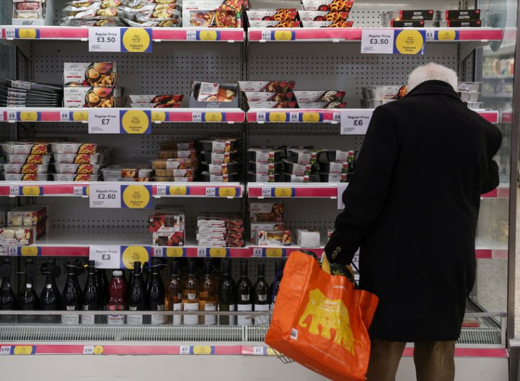 Un homme fait ses courses à l'intérieur d'un supermarché Tesco Extra à Londres