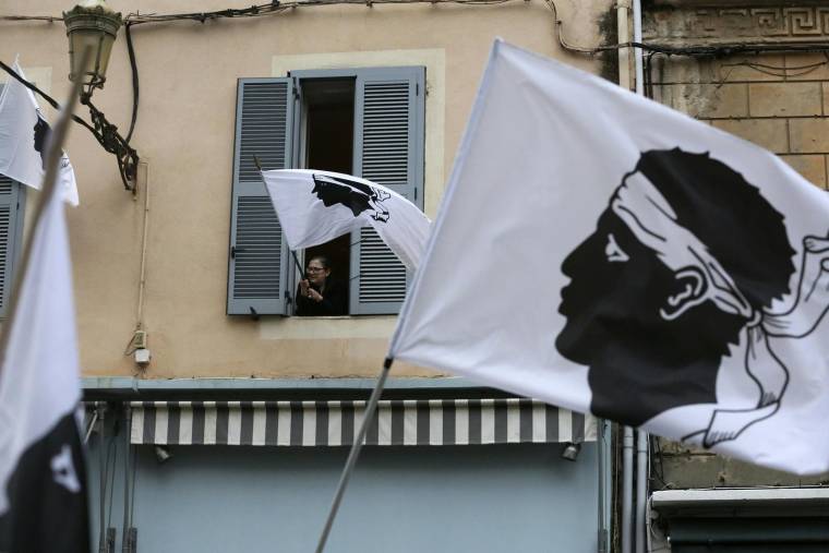 Des manifestants agitent le drapeau corse le 14 mars 2022. ( AFP / Pascal POCHARD-CASABIANCA )