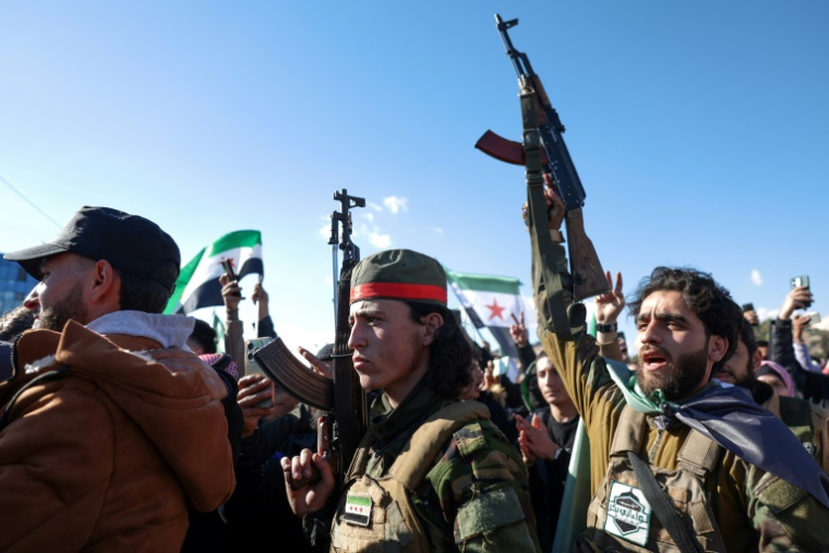 Des rebelles armés participent aux célébrations à Damas après la chute du président Bachar al-Assad, le 13 décembre 2024 ( AFP / OMAR HAJ KADOUR )