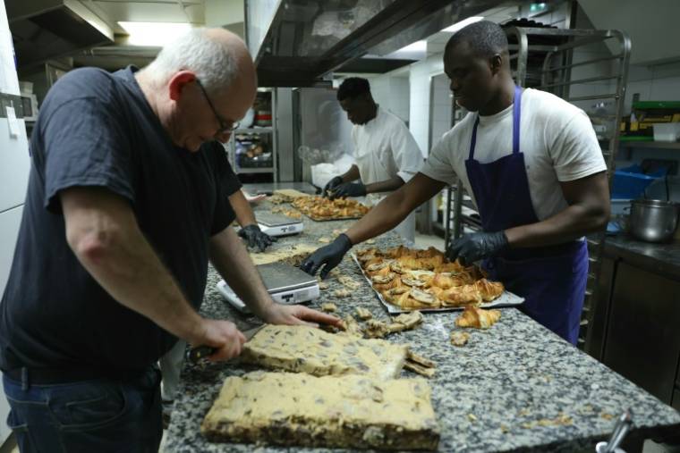 Des employés préparent des crookies, un croissant français traditionnel mélangé à de la pâte à cookies, dans la pâtisserie du chef pâtissier Stéphane Louvard à Paris, le 2 avril 2024 ( AFP / Thomas SAMSON )