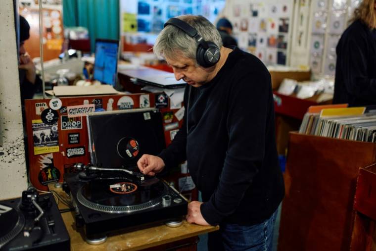 Un client écoute un vinyle de la boutique Flashback Records, le 18 avril 2024 à Londres  ( AFP / BENJAMIN CREMEL )