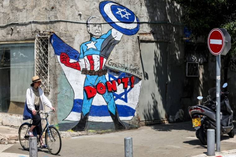Une peinture murale du groupe d'art "Grafitiyul" sur la façade d'un mur de Tel-Aviv, représentant sur un drapeau israélien le président Joe Biden habillé en "Captain America" avec son bouclier et le symbole de l'étoile de David, le 15 avril 2024 ( AFP / JACK GUEZ )