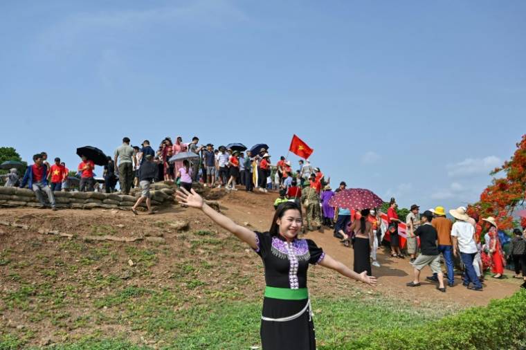 Une Vietnamienne en robe traditionnelle au sommet de la colline A1, site historique de la bataille de Dien Bien Phu, le 6 mai 2024 ( AFP / Nhac NGUYEN )