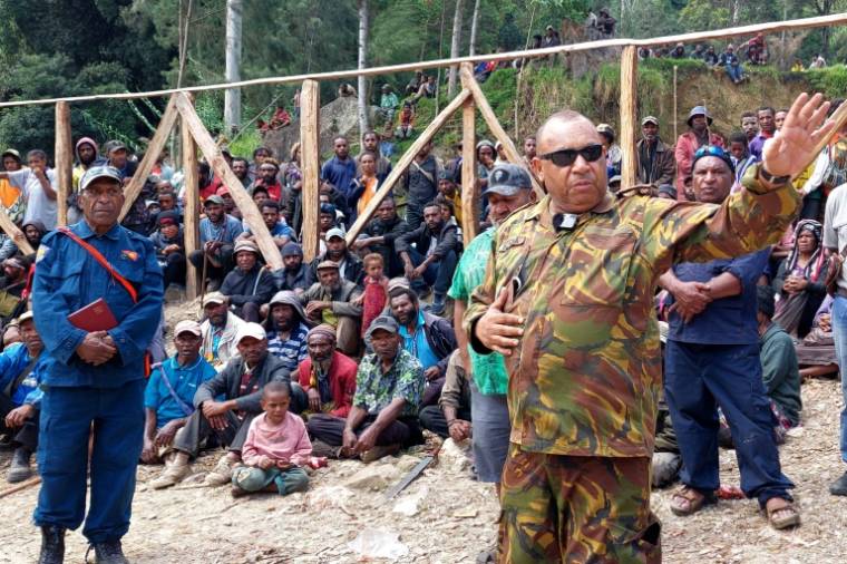 Michael Band, officier des forces de défense de Papouasie-Nouvelle-Guinée, s'entretient avec des habitants sur le site d'un glissement de terrain dans le village de Mulitaka, dans la province d'Enga en Papouasie-Nouvelle-Guinée, le 26 mai 2024 ( AFP / STR )