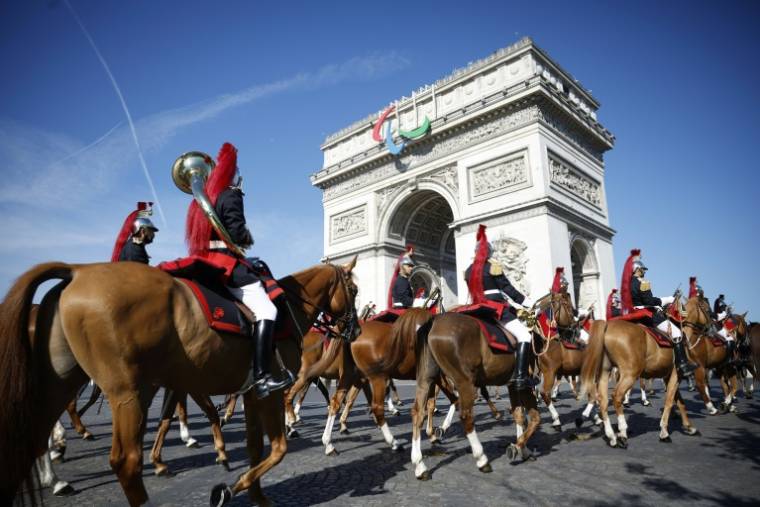 Le régiment de cavalerie de la Garde républicaine française arrive pour se préparer au défilé militaire du Jour de la Bastille sur l'avenue Foch, avec l'Arc de Triomphe en arrière-plan, à Paris, le 14 juillet 2024 ( POOL / Yoan VALAT )