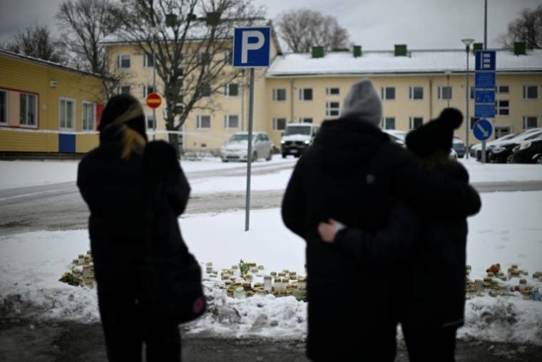 Des habitants se recueillent devant l'école de Vantaa, où un garçon de 12 ans a tué mardi par balles un élève de sa classe et gravement blessé deux filles, le 3 avril 2024 en Finlande ( AFP / Olivier MORIN )