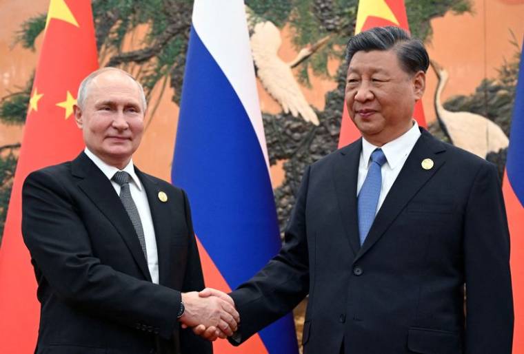 Le président russe Vladimir Poutine serre la main avec le président chinois Xi Jinping à Pékin, en Chine