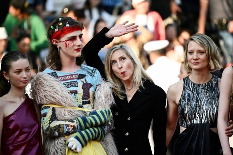 L'équipe du film "Club Zero", dont la réalisatrice Jessica Hausner qui fait un signe de la main, arrive pour sa projection au Festival de Cannes, le 22 mai 2023 ( AFP / LOIC VENANCE )