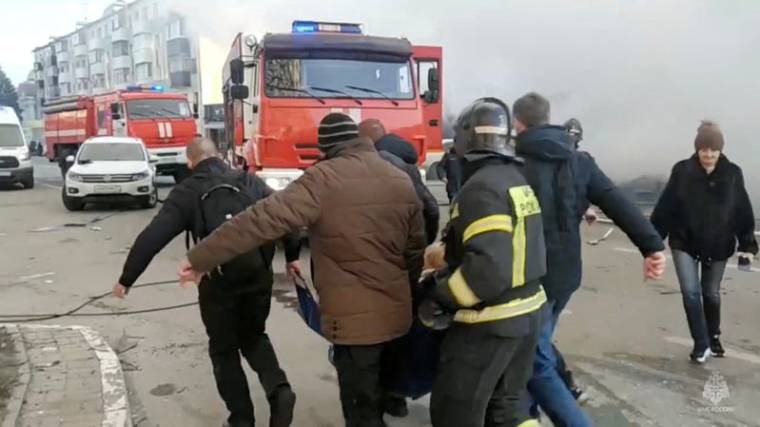 Des personnes, dont des pompiers, transportent une personne hors du site après un bombardement à Belgorod