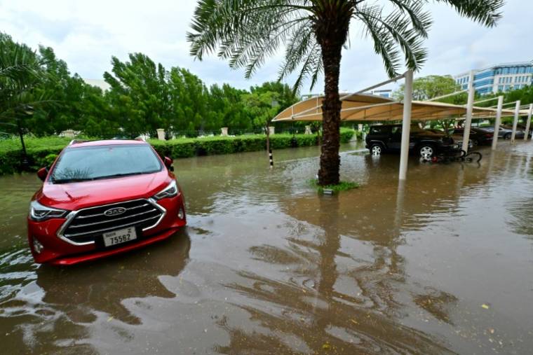 Des véhicules garés dans un parking inondé après des pluies torrentielles à Dubaï, le 16 avril 2024 ( AFP / Giuseppe CACACE )