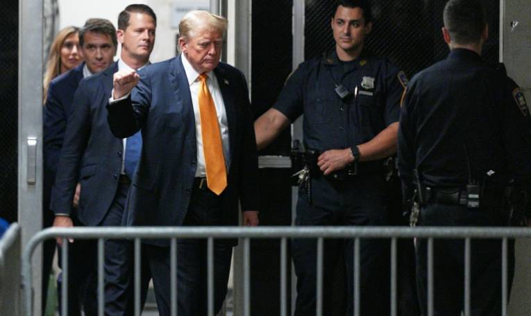 L'ancien président américain Donald Trump, le poing levé, se dirige vers la salle d'audience du tribunal de Manhattan, le 29 mai 2024 à New York ( POOL / Curtins MEANS )