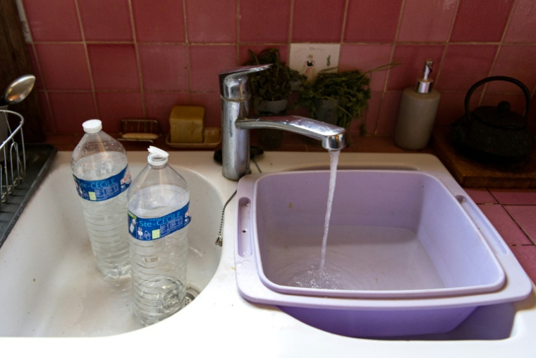 Un habitant remplit une cuvette d'eau à Durban-Corbières, village privé d'eau courante plusieurs heures par jour en raison de la sécheresse, le 22 août 2024 dans l'Aude ( AFP / Matthieu RONDEL )