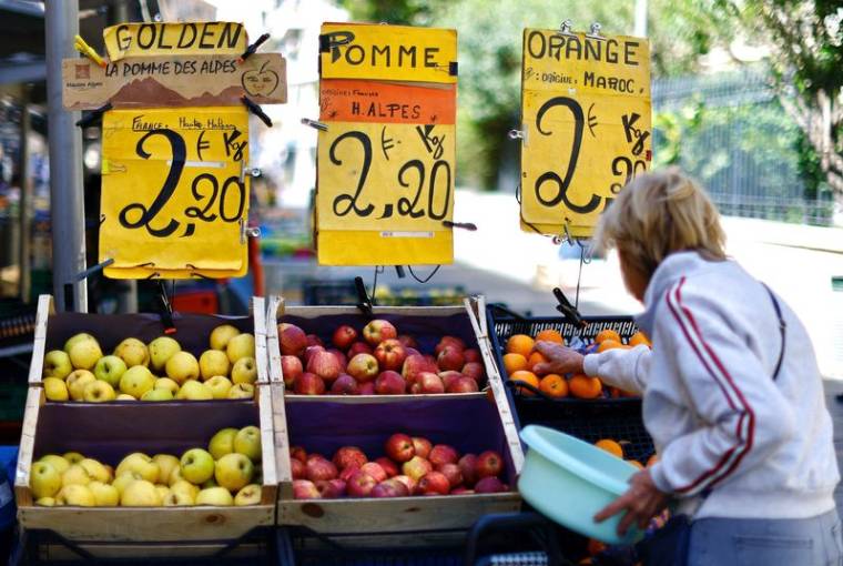 Une femme achète des fruits dans un marché local à Nice