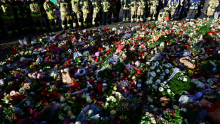 Des pompiers se tiennent devant un mémorial improvisé près du site de l'attaque meurtrière contre un marché de Noël à Magdebourg, en Allemagne, le 22 décembre 2024 ( AFP / John MACDOUGALL )