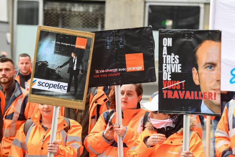 Des salariés de Scopelec, devant le siège de campagne d'Emmanuel Macron, le 7 avril 2022.  ( AFP / ALAIN JOCARD )