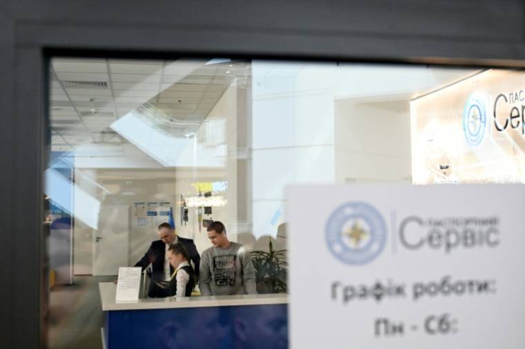 Des employés d'un bureau de délivrance de passeports ukrainiens fermé à Varsovie, le 24 avril 2024 ( AFP / Sergei GAPON )